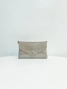 Gros plan d'une pochette argentée avec strass, rabat en V et garnitures métalliques chic