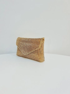 Détail d'une pochette de soirée dorée avec strass scintillants et chaîne en métal