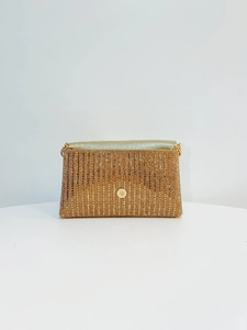 Détail d'une pochette de soirée dorée avec strass, boucle magnétique et doublure