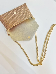 Détail de la pochette dorée en strass avec fermoir magnétique et bandoulière chaîne