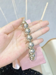 Macro detail of high-polish silver beads showing mirror-like metallic finish and smooth texture