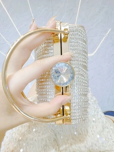 Close-up of luxury evening clutch with sparkling rhinestones and metal round handle