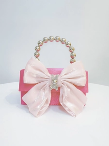 Detail of rose red satin evening bag with pink bow, bunny jewel, and silver pearl handle