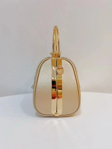 Detail of gold crystal evening clutch with smooth metal handle and side buckle