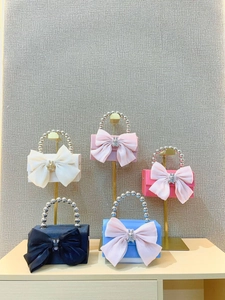 Detail of evening clutches featuring large tulle bows and rabbit metal buckles in five colors