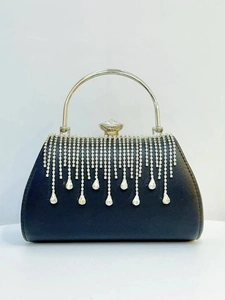 Detail of elegant black evening clutch with sparkling silver rhinestones and long tassels