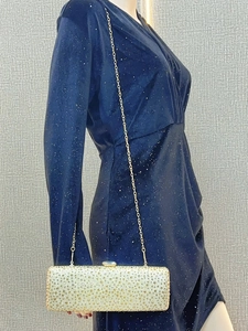 Detail of elegant gold evening clutch bag with full rhinestones and detachable metal chain
