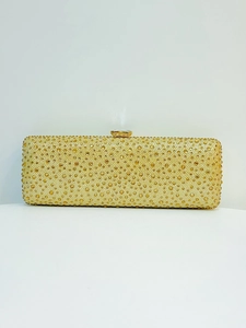Detailed view of luxury gold evening clutch featuring dense rhinestone inlay and gem clasp