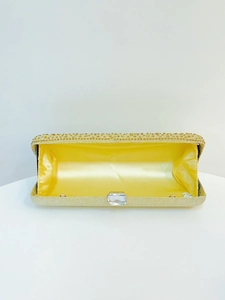 Detail of yellow evening clutch with gold rhinestones and bright satin lining