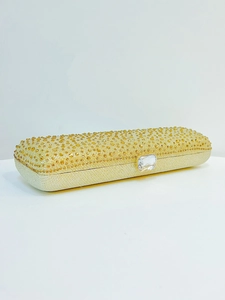 Detail of gold crystal evening clutch bag with sparkling rhinestones and transparent clasp