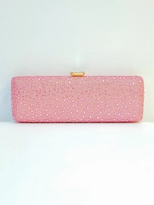 Macro shot of pink rhinestone encrusted evening bag with golden frame and square diamond clasp