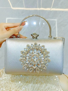 Detailed view of silver rhinestone evening clutch bag with sparkling floral pattern and metal handle
