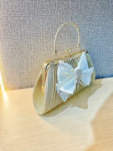 Elegante pochette dorata con grande fiocco in pizzo e strass per feste