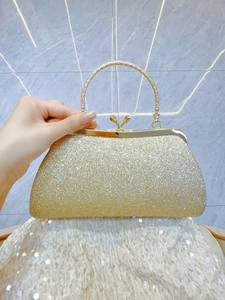Dettaglio della borsa da sera con paillettes dorate e manico rotondo in metallo