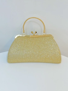Dettaglio del materiale glitterato dorato e della cornice metallica della borsa da sera