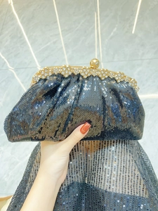 Detail of elegant black sequin evening clutch bag with luxury crystal flower clasp