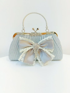 Dettaglio di borsa da sera argento con frange di strass, fiocco e pizzo elegante