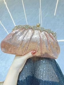 Close-up of rose gold sequin evening clutch bag with crystal flower clasp detail