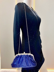 Detail of royal blue sequined evening clutch with silver floral metal clasp and chain