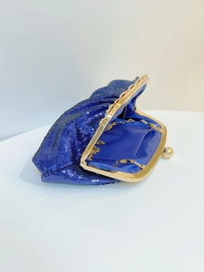 Close-up of royal blue sequined evening clutch with gold metal frame and chain strap