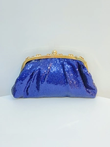 Detail of dark blue sequined evening clutch bag with elegant gold metal frame and clasp