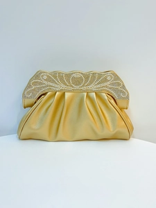 Detail of gold evening clutch with pleated texture, pearls, and sparkling rhinestones