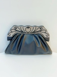 Close-up of elegant black evening clutch with rhinestone pattern and pleated matte leather