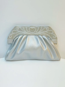 Macro detail of silver rhinestone evening clutch bag with pearl accents and pleated finish