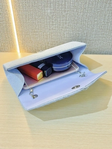 Detail showing the inner storage of a sparkling glitter evening clutch with a metal chain