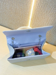 Detail view of silver glitter clutch bag with interior space for phone and makeup