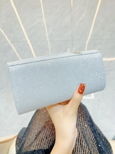 Close-up of elegant silver glitter evening clutch with rectangular hard shell and metal clasp