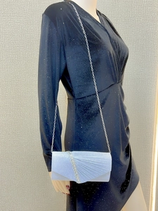 Detail of silver blue pleated evening clutch bag with sparkling diamond strap and chain