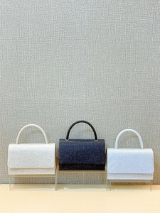 Sparkly evening handbags in white, black, and blue with round handles for formal events
