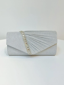 Close-up of sparkling silver evening clutch with rhinestones and pleated fabric texture