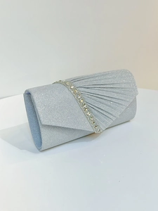 Detail of pleated silver evening clutch bag featuring a single row of sparkling rhinestones