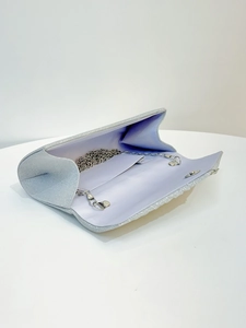 Detail of silver glitter evening clutch with light purple lining and metal chain strap