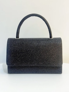 Detailed view of black glitter evening clutch featuring a rigid top handle and sparkle finish