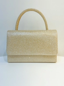 Macro detail of golden glitter texture and metallic finish on a rectangle evening clutch