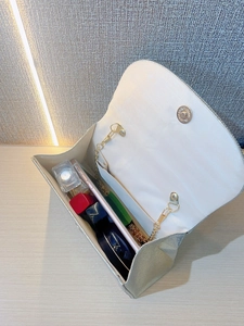 Detail of silver rhinestone clutch interior with magnetic snap and metal chain strap