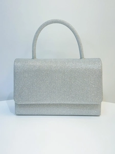 Detail of silver glitter evening clutch bag with rectangular flap and curved handle