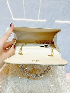 Champagne gold rhinestone clutch bag with sparkling finish and twisted crystal handle