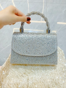 Detail of silver rhinestone evening clutch with twisted handle for formal banquet
