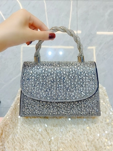 Detail of silver rhinestone evening bag with twisted crystal handle and shimmering finish