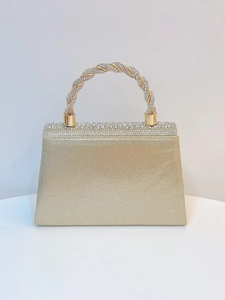 Close-up of gold evening bag featuring rhinestone-encrusted handle and glittery finish