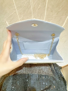 Pale blue rhinestone evening clutch with pearl trim and gold chain shoulder strap
