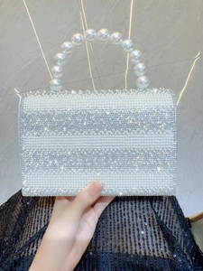 Detail of beaded evening clutch with white pearls and sparkling silver rhinestones