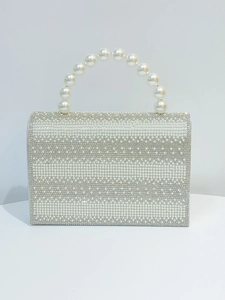 Close-up of elegant faux pearl handle and crystal rhinestone evening bag texture