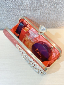 Detailed view of sparkly pink evening clutch interior with rhinestone and crystal clasp
