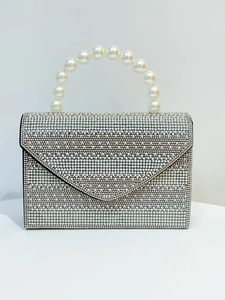 Detail of silver evening bag with encrusted rhinestones and pearl beaded handle