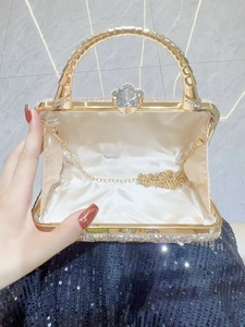 Golden sparkling evening bag with rhinestone exterior and flower clasp including metal chain